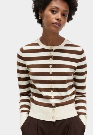 Brązowo-kremowy kardigan w paski z okrągłym dekoltem i zapięciem na guziki z przodu. Miękka tkanina, dopasowana talia i prążkowane mankiety.