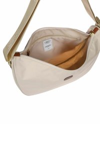 Borsa a tracolla beige con tracolla regolabile, scomparto principale aperto che mostra la fodera interna in tessuto e la tasca interna con cerniera con etichetta del marchio.