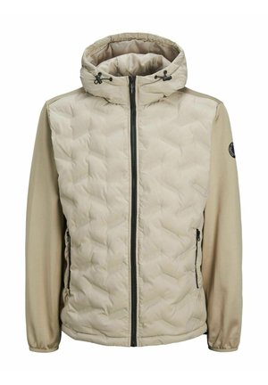 Bézs szigetelt dzseki steppelt elülső résszel, sima hosszú ujjaival, állítható kapucnival és cipzáras zsebekkel; a hüvelyén logó található.