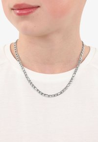 Collana in argento con anelli interconnessi, caratterizzata da una finitura lucida. Indossata su un indumento bianco, design minimalista.