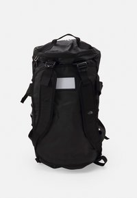 Sac à dos noir en matériau durable, avec des bretelles ajustables, une poignée supérieure et un panneau réfléchissant à l'avant.