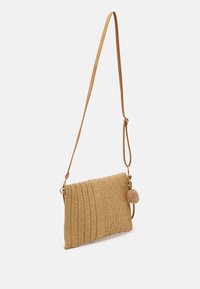 Borsa a tracolla in paglia intrecciata di color beige chiaro, con un design texturizzato, profilo sottile e un accento a pompon staccabile. Inclusa tracolla regolabile.