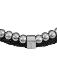 Schwarzes geflochtenes Lederarmband mit silberfarbenen Metallperlen und einem rechteckigen Verschluss, der mit "FOSSIL" markiert ist. Glatte Textur, schlichtes Design.