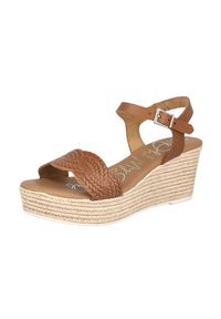 Sandalias de cuña de cuero marrón con tira frontal trenzada y hebilla en el tobillo. Base de yute natural trenzado, superficie texturizada y plantilla suave.