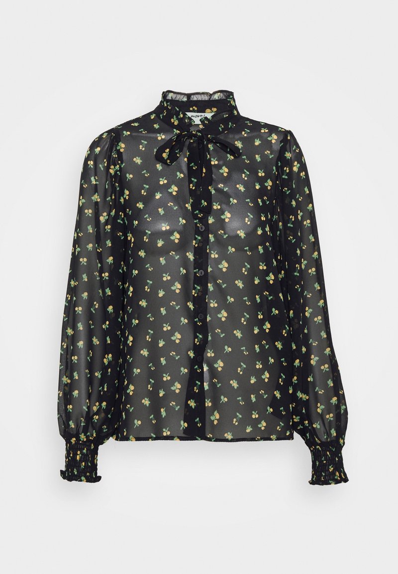 Black sheer blouse with small floral print in green and yellow, button front, tie neck, and elastic cuffs with ruffled edges.