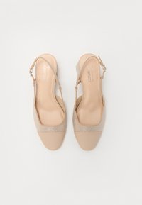 Béžové slingback podpatky s hladkým matným povrchem, síťovinovými detaily a dekorativním páskem, s nízkým blokovým podpatkem.