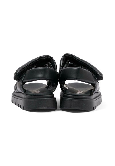 Paire de sandales noires matelassées avec semelles épaisses et brides réglables à la cheville, vues de dos sur fond blanc.