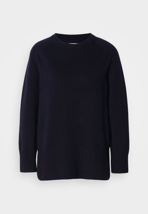 Tumedast mereväest sinine ümarakaelusega pikade varrukatega sviiter pehme kudumise tekstuuri ning soonikkudumisega varruka- ja alumise servaga helesinise tausta ees.