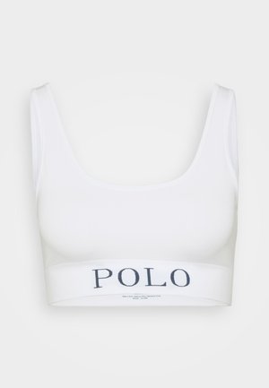 Balta sporta krūšturis ar platām plecu siksnām un jostu, uz kuras rakstīts "POLO" tumši zilā krāsā. Gluda tekstūra un pieguļoša forma.