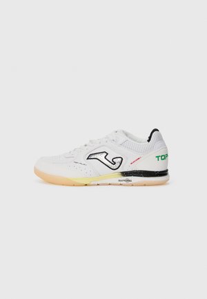 Witte sport schoen met geperforeerde textuur, zwarte en rode accenten, en een rubberen zool. Beschikt over een opvallend zwart logo en een gevoerde kraag.