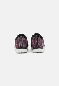 Zapatillas de punto negras y rosas con un acabado texturizado, suela blanca y tapa de talón con marca. Diseño ligero adecuado para un uso casual.