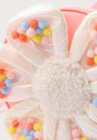 Ronde roze tas met een groot bloemenpatroon en iriserende bloemblaadjes, gevuld met kleurrijke pom poms en een zachte, pluizige crèmekleurige kern.