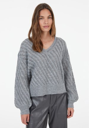 Hellgrauer gestrickter Pullover mit V-Ausschnitt, der ein strukturiertes Muster und lockere Ärmel aufweist. Rippbündchen am Saum und an den Ärmeln sorgen für zusätzliche Details.