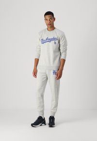 Grauer Sweatshirt mit blauer "Los Angeles"-Schrift, kombiniert mit passenden grauen Jogginghosen. Mit gerippten Bündchen und Logo-Akzenten. Athletische Schuhe sind inklusive.