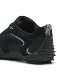 Sneaker nera caratterizzata da un mix di materiali in camoscio e rete. Suola in gomma testurizzata con tacchetti, accenti argentati e un pull tab grigio a strisce.