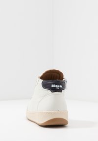 Hvide læder høje sneakers med en tekstureret cremefarvet sål, mørkeblå hælflap og brun polstret krave. Har en lynlåslukning i siden.