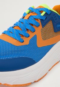 Sport shoe featuring a blue mesh upper with orange accents, contrasting green details, and a white textured outsole.