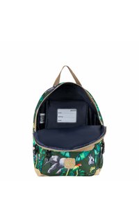 Groene stoffen rugzak met dieren- en bladpatronen, tan accenten en een ruime marineblauwe binnenkant met een naamlabel en een ritsvak.