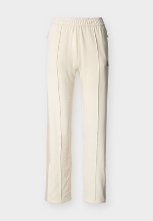 Pantalon droit couleur crème en tissu doux, doté d'une taille élastique, de poches latérales et de coutures discrètes.