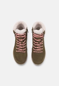 Une paire de bottes d'hiver vert olive avec des lacets roses et une doublure en polaire blanche, vues de dessus sur un fond blanc.