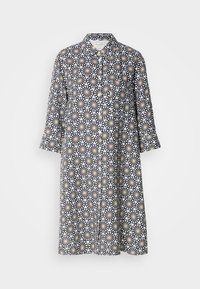 Robe-chemise longueur genou à manches longues et motif géométrique de marguerites noires, blanches et jaunes, boutonnée devant.