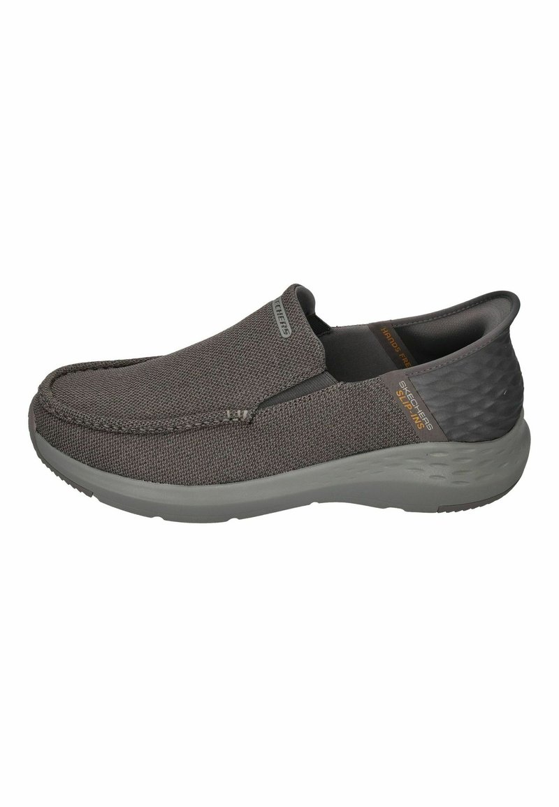 Gray slip-on shoes with a textured fabric upper and smooth gray rubber sole. Features elastic side panels for easy wear and a subtle logo detail.