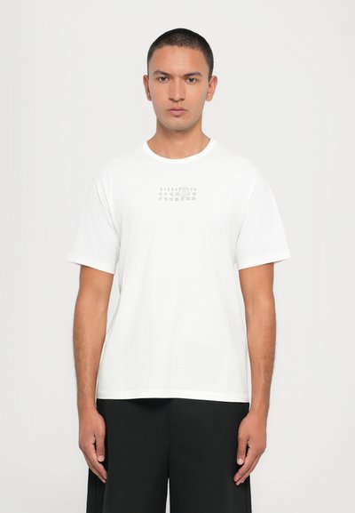 Witte katoenen T-shirt met een kleine bedrukte graphic van cijfers op de borst. Korte mouwen en een ronde halslijn met een rechte zoom.