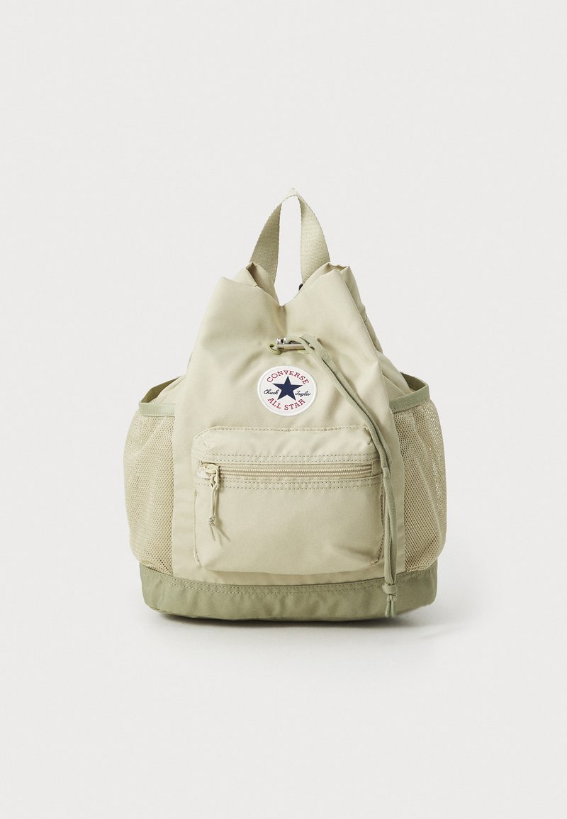 Khaki vihreä reppu, jossa on nauhakiinnitys, verkkopinnat, etutasku vetoketjulla ja pyöreä logopatch, jossa on tähti. Sujuva pinta.