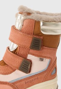 Bota de cuero marrón y tela con dos correas ajustables, forro de lana, acentos plateados y una suela resistente, que presenta el nombre de la marca "bisgaard."