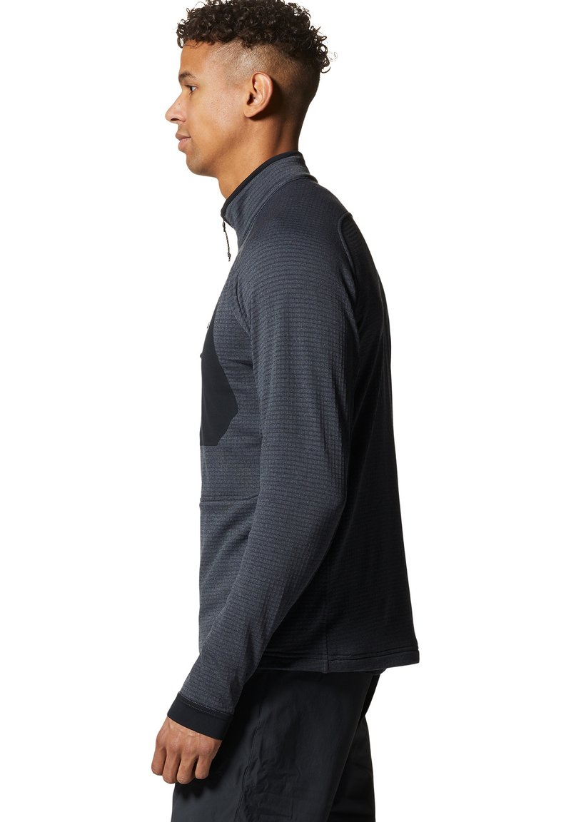 Czarna kurtka sportowa zapinana na zamek, wykonana z teksturowanej tkaniny. Posiada jednolitą czarną panel na klatce piersiowej oraz czarne mankiety. Długie rękawy, dopasowany krój.