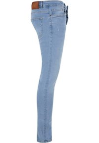Jean skinny bleu clair avec une texture en denim lisse, taille mi-haute, accents de poches arrière, et un patch en similicuir marron sur la ceinture.