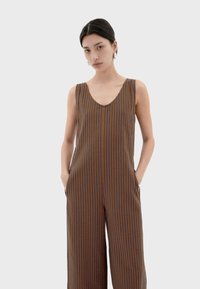 Bruin en marineblauw gestreepte mouwloze jumpsuit met een V-hals, zijzakken, een losse pasvorm en een zachte textuur.