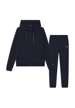Tuta in blu navy composto da una felpa con cappuccio e zip, dotata di cordini, e pantaloni coordinati, entrambi realizzati in materiale morbido con dettagli del logo.