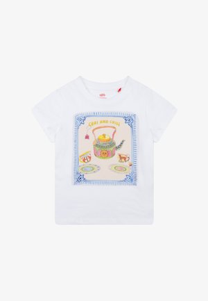 Wit T-shirt met korte mouwen met een kleurrijke afbeelding van een theepot, kopjes en patronen, met de tekst "CHAI AND CHILL" in een decoratieve rand.