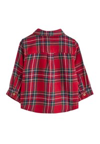 Chemise à carreaux rouge avec des accents verts et blancs, un col pointu, des manches longues avec des poignets boutonnés et un ourlet arrondi. Texture douce.