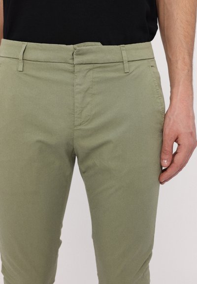 Khakifärgade byxor med en slät textur, framfickor, midjeband med bälteshällor, slim fit-design och ren, minimal sömnadsdetaljering.