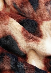 Zachte, pluizige deken in bruin, beige en donkerblauw dierenprint. Kenmerkt zich door een rijke textuur met gevarieerde schaapachtige patronen en gladde accenten.