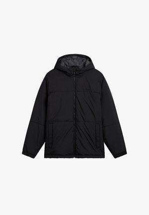 Chaqueta acolchada negra con capucha, con un cierre frontal, dos bolsillos laterales y un logo sutil en el pecho. Textura exterior suave.