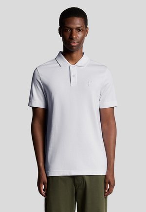 Weißes Poloshirt mit Kragen, kurzen Ärmeln und einem dezenten gestickten Logo auf der Brust. Glattes Baumwollgewebe, taillierte Passform.