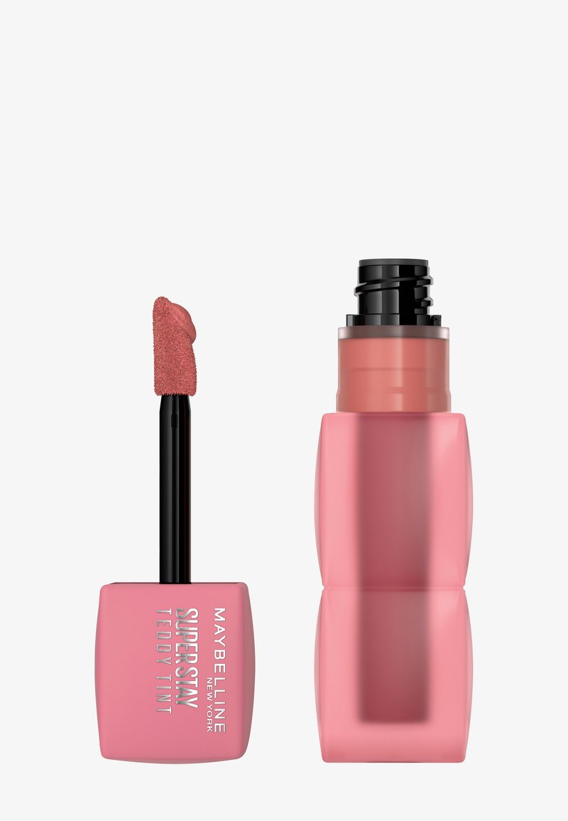 Maybelline Super Stay Teddy Tint, met een zachtroze rechthoekige verpakking, zwarte deksel en een paddle-applicator met een roze tint.