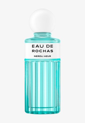 Wysoka turkusowa żebrowana szklana butelka perfum z białą kulistą nakrętką i białą etykietą z napisem „Eau de Rochas Neroli Azur.”