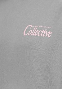 Grauer Kapuzenpullover mit einem pinkfarbenen bedruckten Logo, auf dem "UNLIMITED YOUNG AUTHENTIC" über dem Wort "Collective" steht. Weiche, glatte Textur.