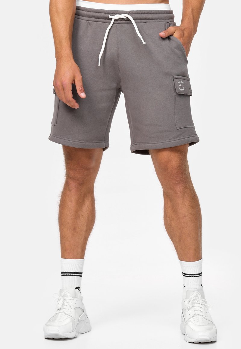Shorts de survêtement gris avec taille à cordon, poches latérales et une poche cargo sur le côté droit. Fabriqués en tissu doux en mélange de coton.