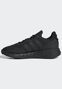 Melnas sporta kurpes ar teksturētu acu augšdaļu, trim horizontālām svītrām, mīkstinātu zoli un elegantu dizainu, kas piemērotas sportam un ikdienas nēsāšanai.