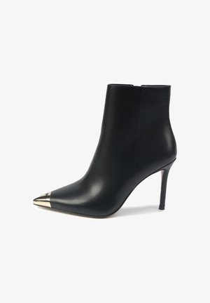 Sort læder ankelstøvle med spids tå, metallisk guldkappe akcent og stilettohæl. Glat finish og tætsiddende design.