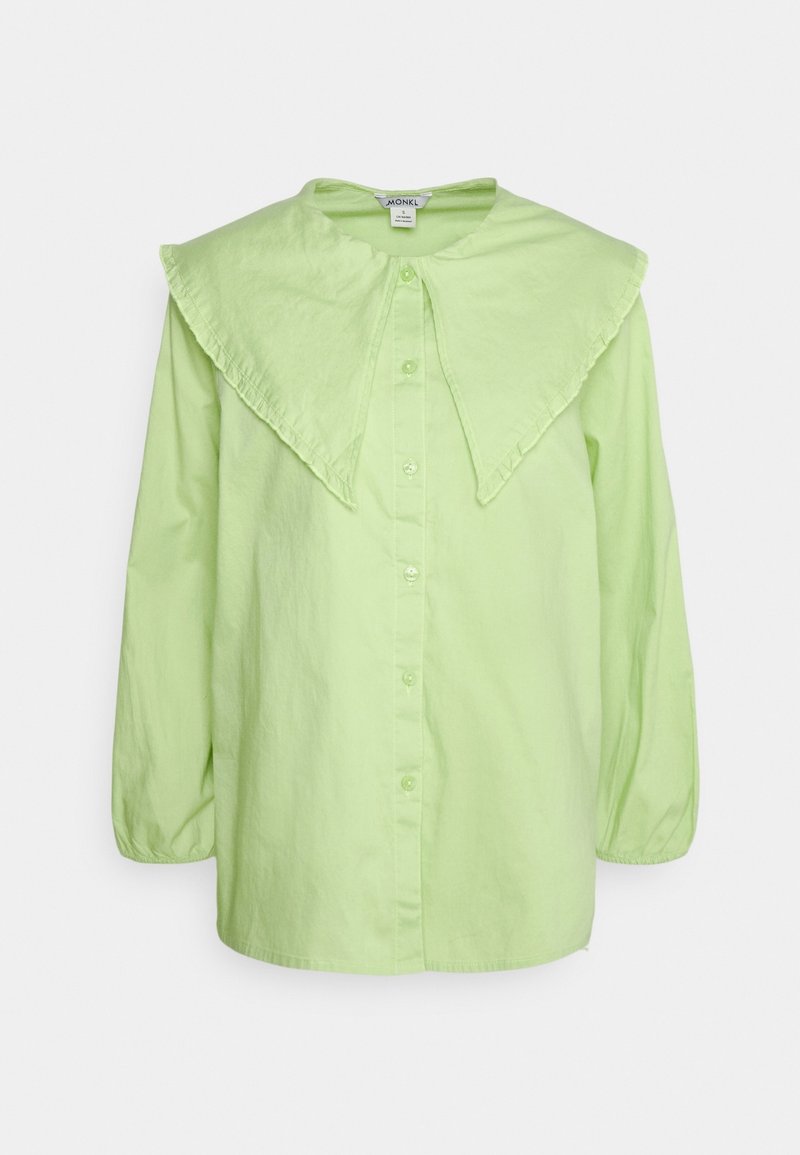 Blouse vert clair à manches longues avec boutons, col pointu oversize et poignets légèrement froncés.