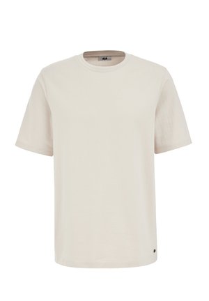 Camiseta de manga corta color beige claro hecha de tela texturizada, con escote redondo y un pequeño detalle de logo cerca del dobladillo.