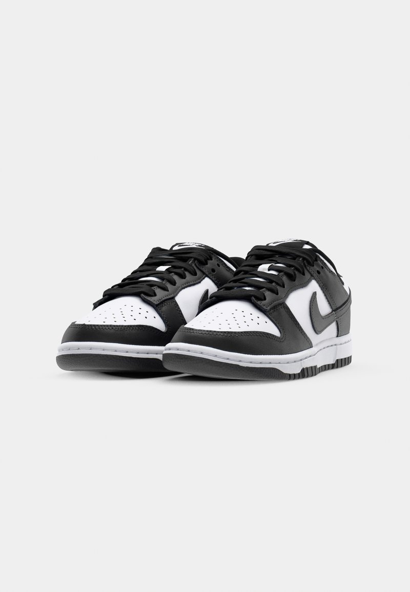 Schwarz-weiße Low-Top-Sneaker mit Obermaterial aus Leder, durchlöchertem Zehenbereich, flachen schwarzen Schnürsenkeln und signatur Logo an der Seite. Gummisohle.