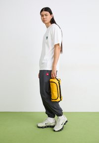 The North Face TRAVEL CANISTER  - Geantă cosmetice - gold-coloured/black
