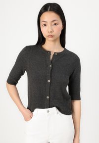 Cardigan gris charbon à manches courtes en matériau doux, avec un bouton avant entier, un col arrondi et un ourlet et des poignets côtelés.